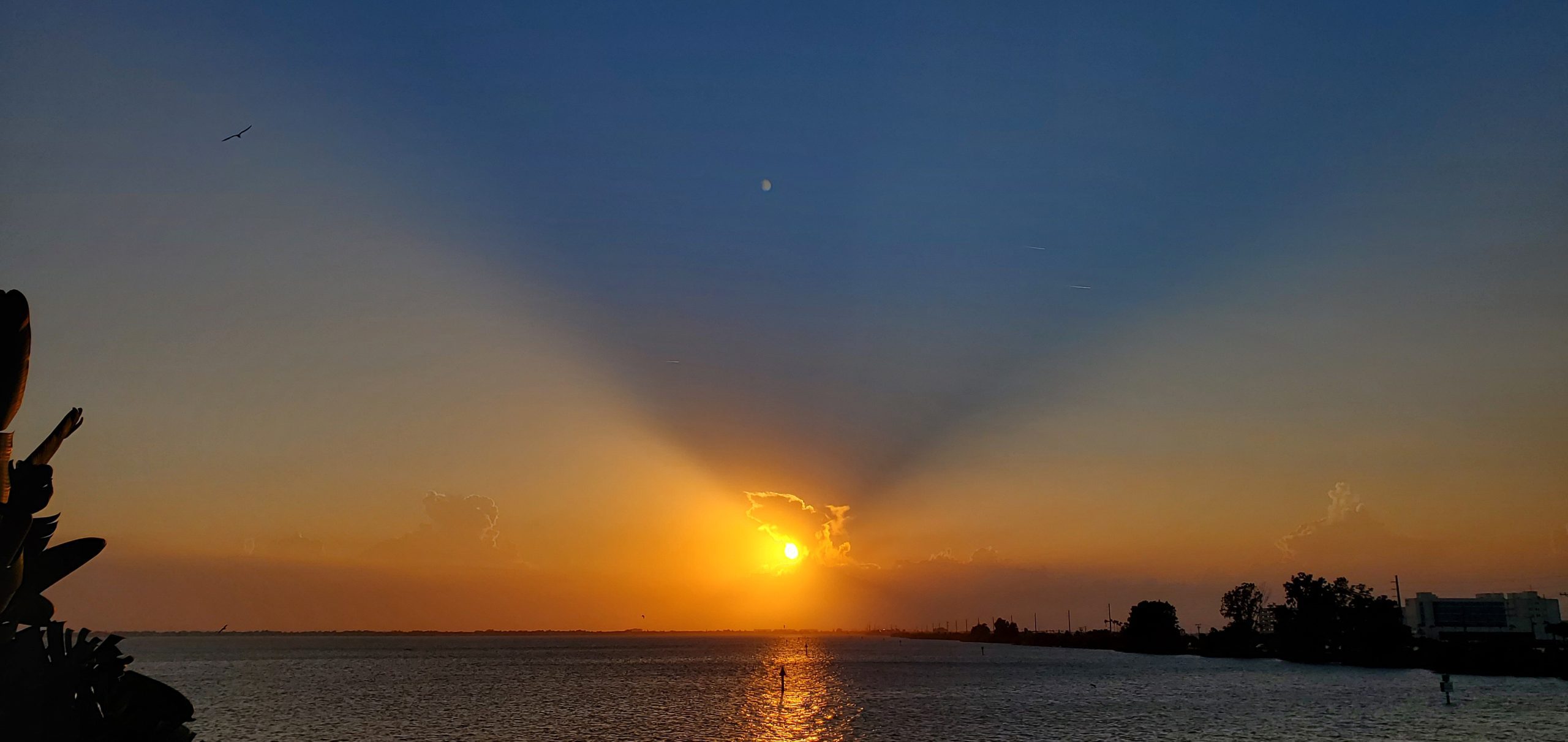 Bright sunburst over the water during a Space Coast sunset