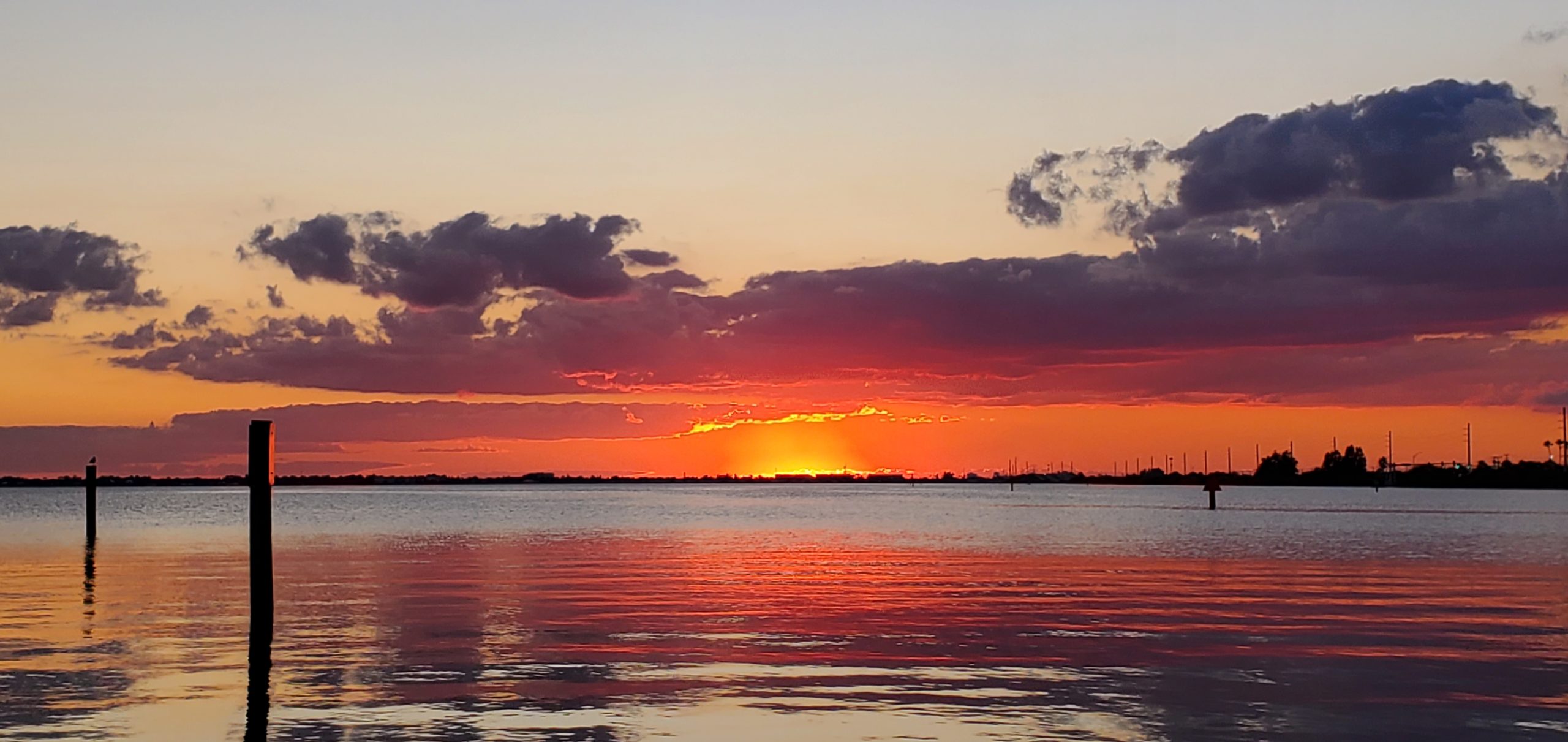 Red and pink sunset clouds reflecting on calm water near Port Canaveral