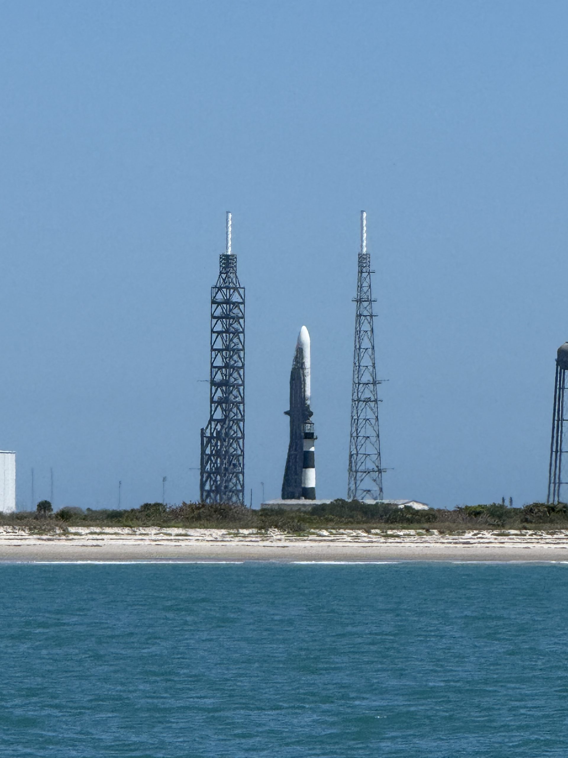 Rocket standing on the launch pad at Cape Canaveral, seen from the water on a boat tour